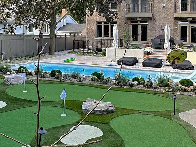 Backyard with pool and artificial turf putting green