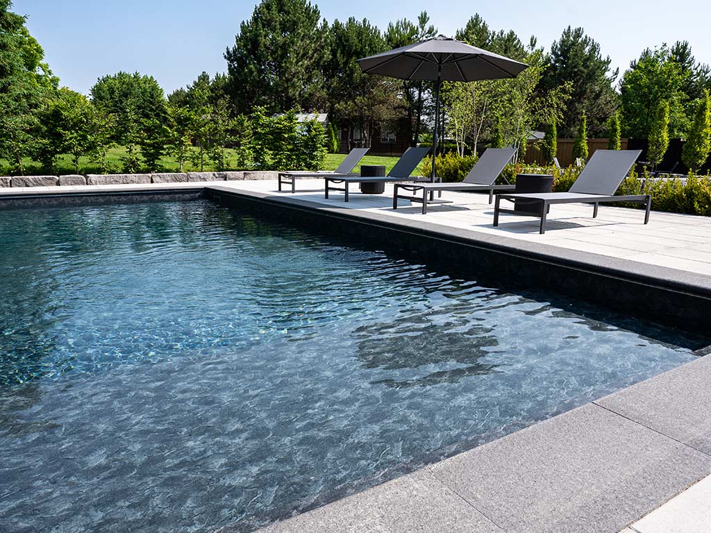 Image showing a swimming pool and stone deck construction in Uxbridge, ON by Greenblock Landscape Property Services