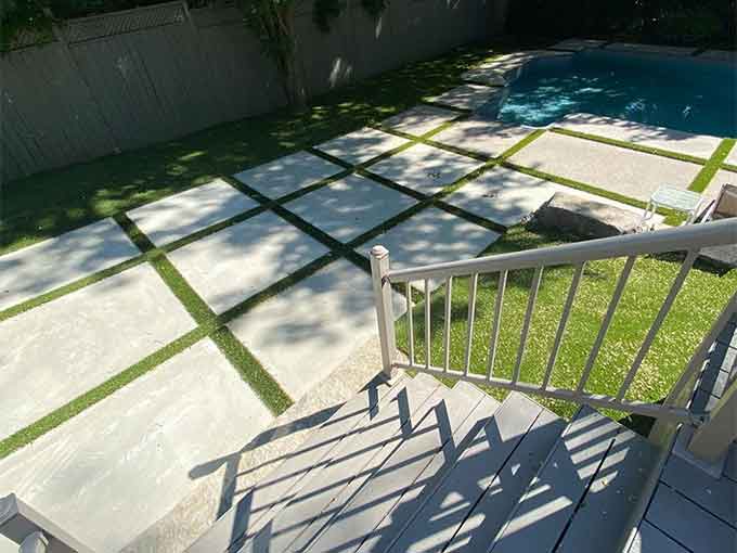 Backyard with large pavers, turf, and a pool area.