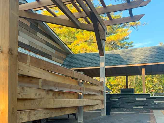 Wooden pergola overlooking a patio with stone features.